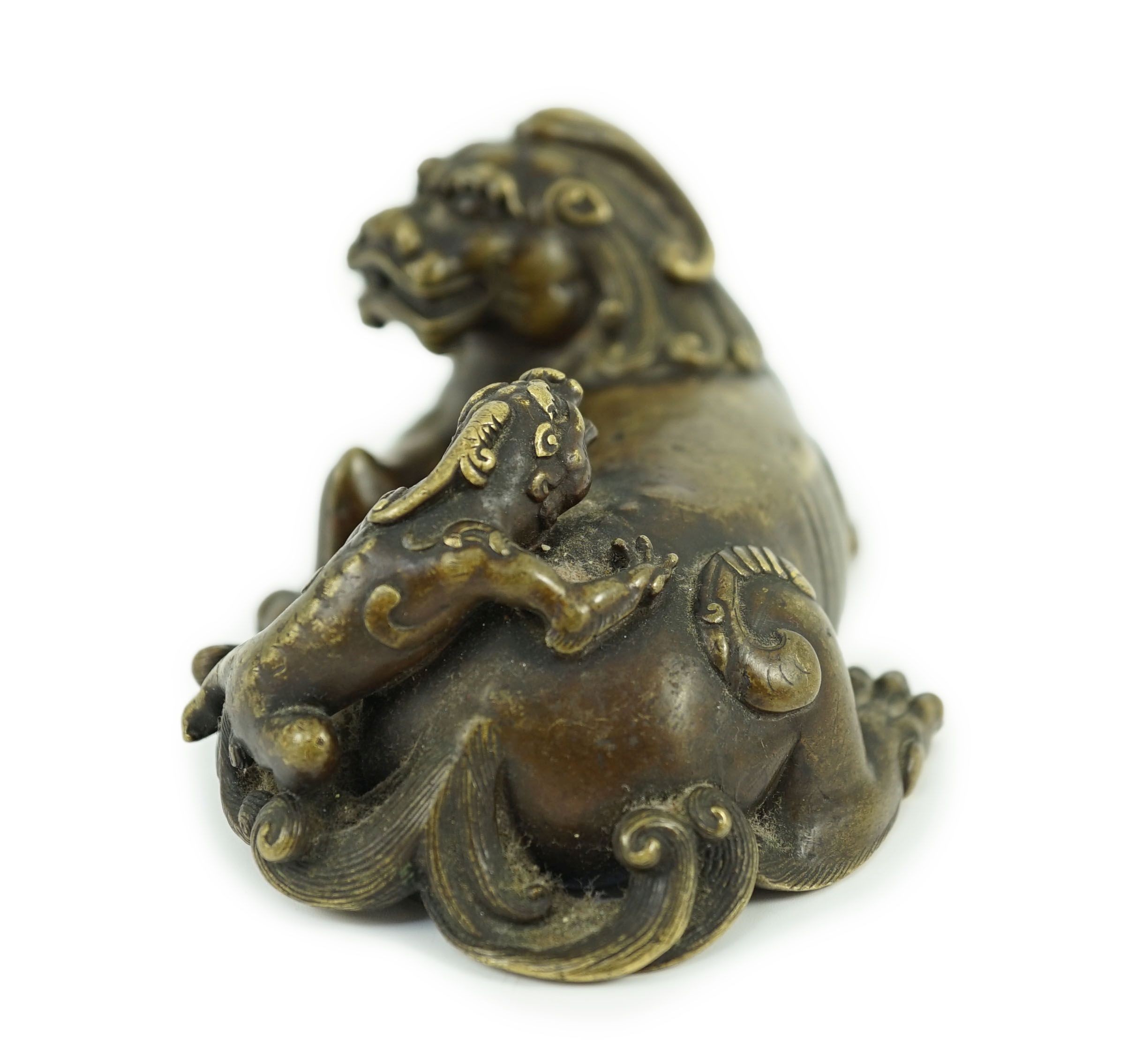 A finely cast Chinese bronze lion-dog and cub scroll weight, 17th/18th century, 14cm long, one foot and a cub lacking